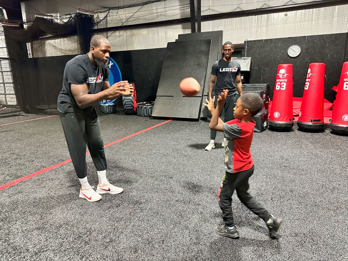 Mohamed Sanu plays catch at Legacy Sports Complex while Christian Blake watches in the background.